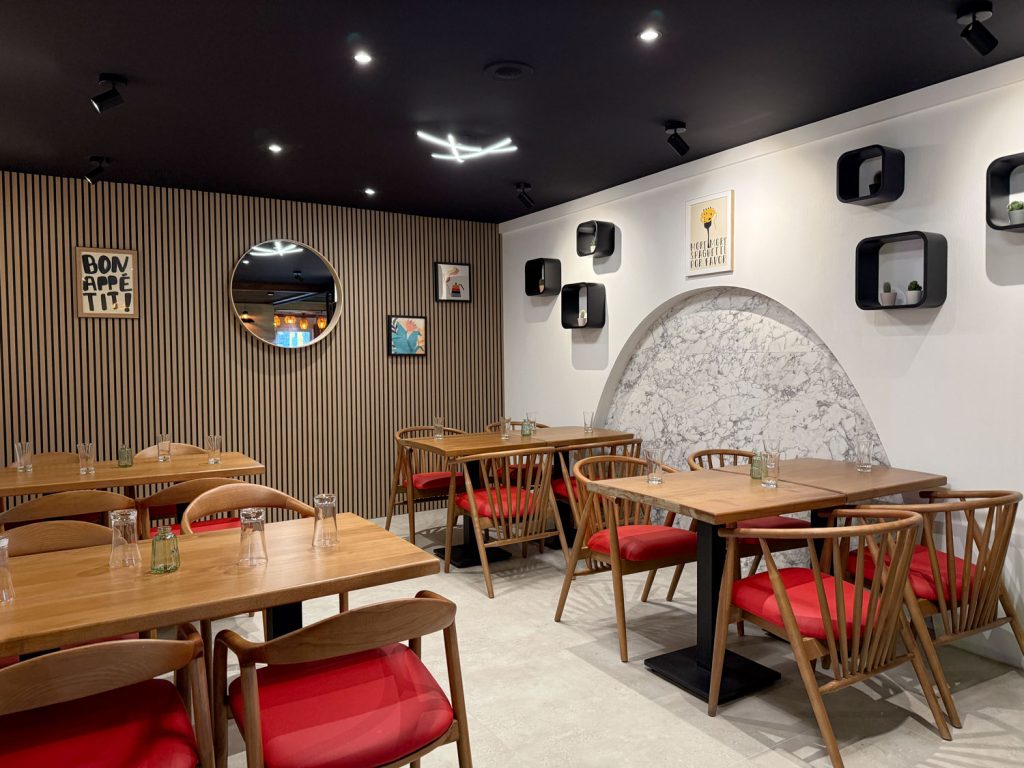 Salle du restaurant halal O'Grill à Dijon avec touches rouges, mur en marbre et déco moderne
