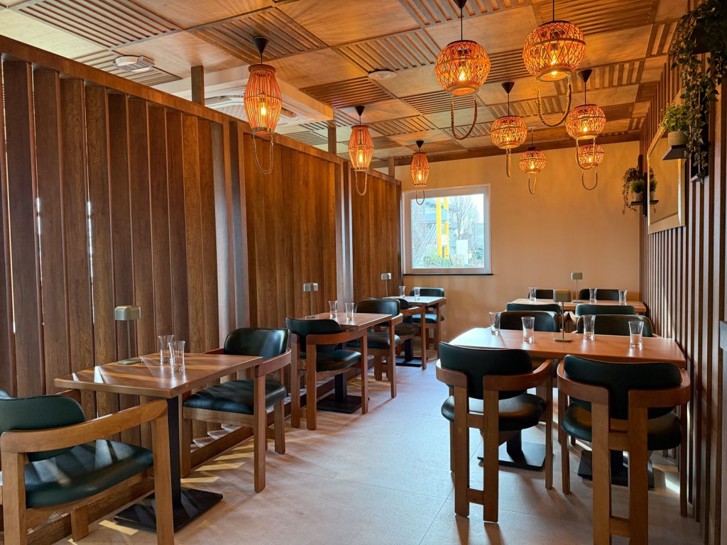 Salle chaleureuse du restaurant halal O'Grill près de Dijon, ambiance bois et suspensions rotin