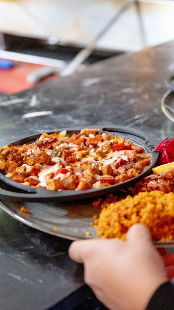 Güveç turc halal aux tomates, poivrons et fromage fondu servi en poêlon avec du boulgour au restaurant O'Grill près de Dijon