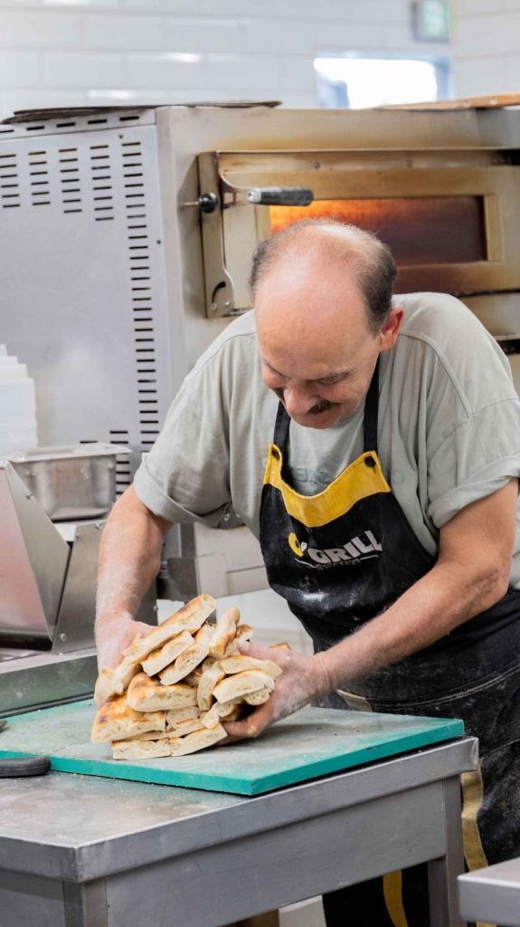 Boulanger d'O'Grill sortant du four des pains pide faits maison, cuisine du restaurant turc halal près de Dijon