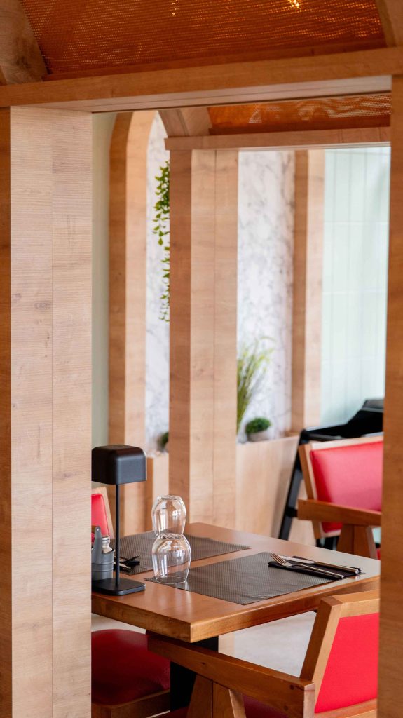 Table dressée dans une alcôve en bois avec arches et fauteuils rouges au restaurant turc halal O'Grill à Marsannay-la-Côte